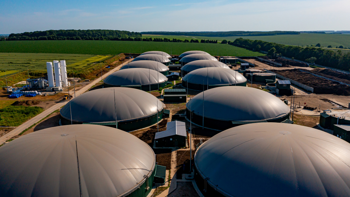 Aerial view of biofuel storage tanks beside farmland supporting climate-smart feedstock production.