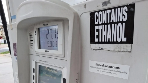 Close-up of a fuel pump with a Contains Ethanol sign and a digital readout showing fuel price and gallons