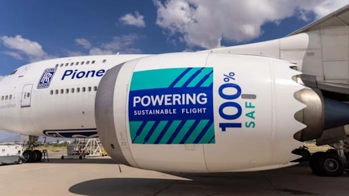 Large commercial aircraft engine displaying Powering Sustainable Flight and 100% SAF branding on the ground