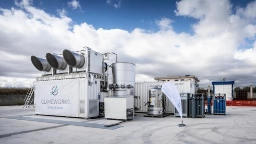 The Climeworks carbon capture unit with four circular fans on a branded container and tanks at an outdoor site